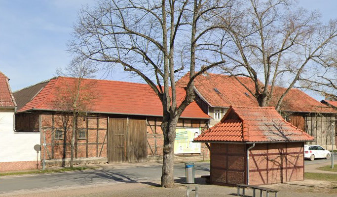 Ein Google-Street-View-Bild mit der Straßenfront aus Backstein und einem großen hölzernen Tor